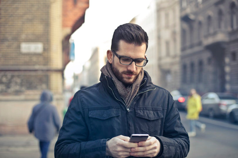 Man posting on social media via smartphone