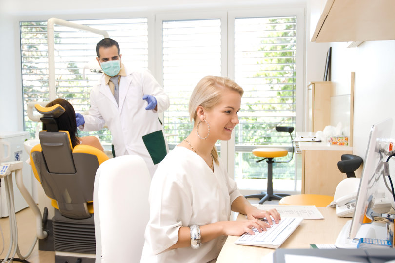 Dental assistant working on a laptop