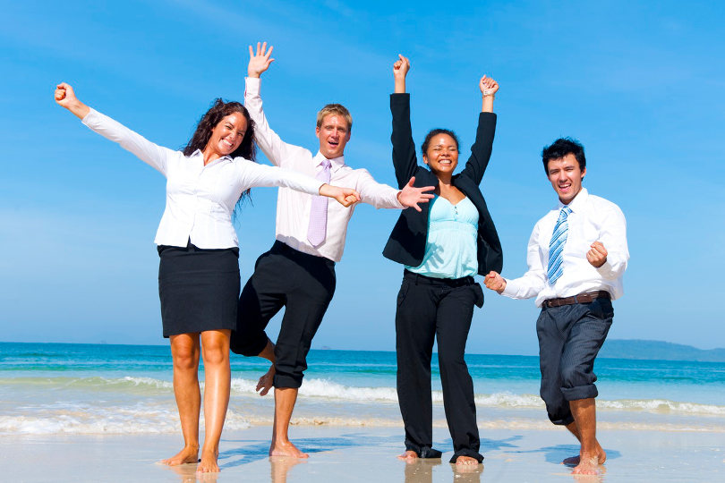 Business people having fun on the beach in a corporate retreat