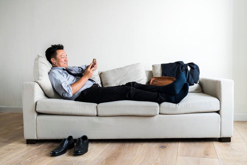 Businessman laying down on a couch