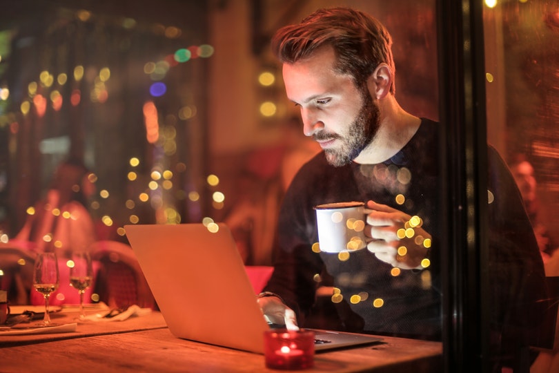 Man drinking coffee while using the Internet