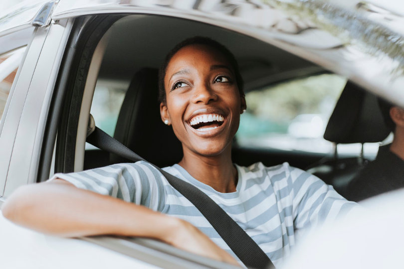 Happy car owner driving safely