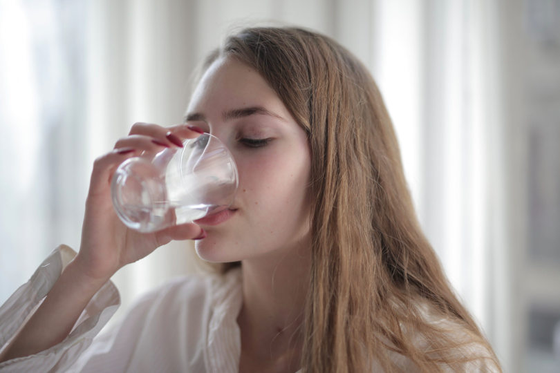 A woman drinks water.