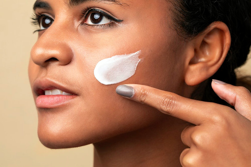 Woman applying skincare product