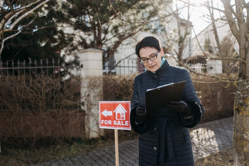 Real estate agent and the House for Sale sign