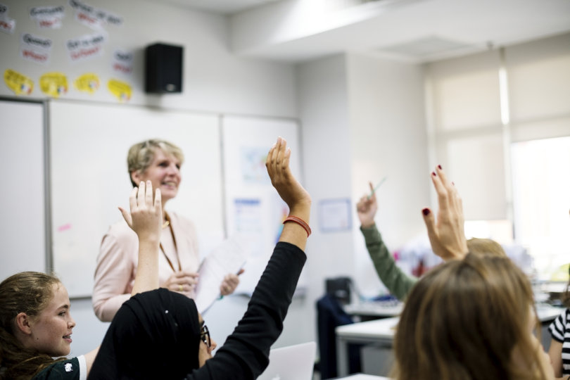 Lehrer und Schüler in einem Klassenzimmer.