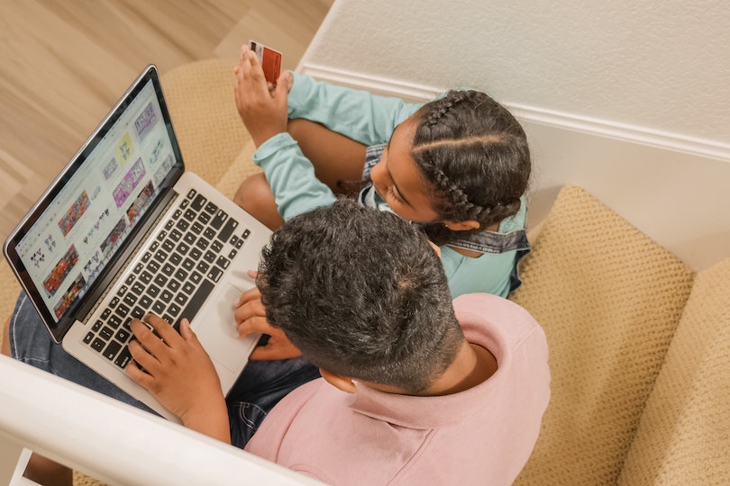 Child shopping online with her dad using a debit card